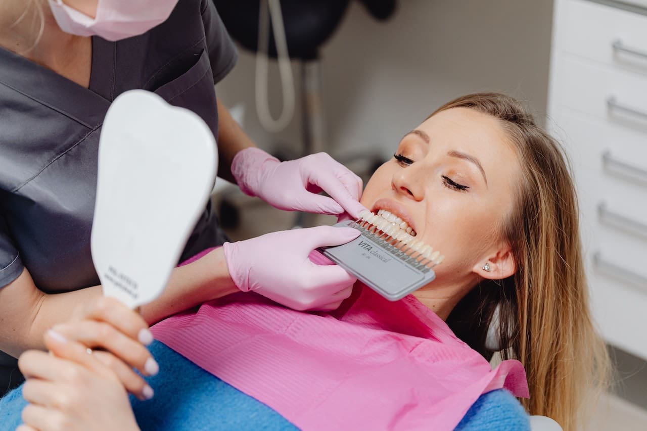 Dentist matching veneers with patient's tooth color